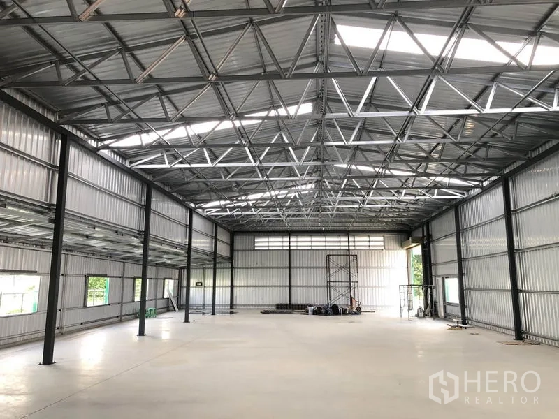 Warehouse for rent in Don Mueang, Bangkok - Spacious clear-span warehouse hall with skylights, side windows and an open loading area.