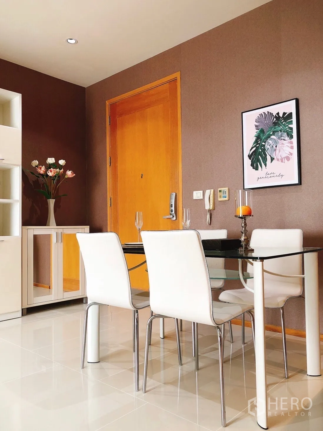 Condominium for rent in Khlong Toei, Bangkok - Contemporary glass dining table with white chairs set for two.