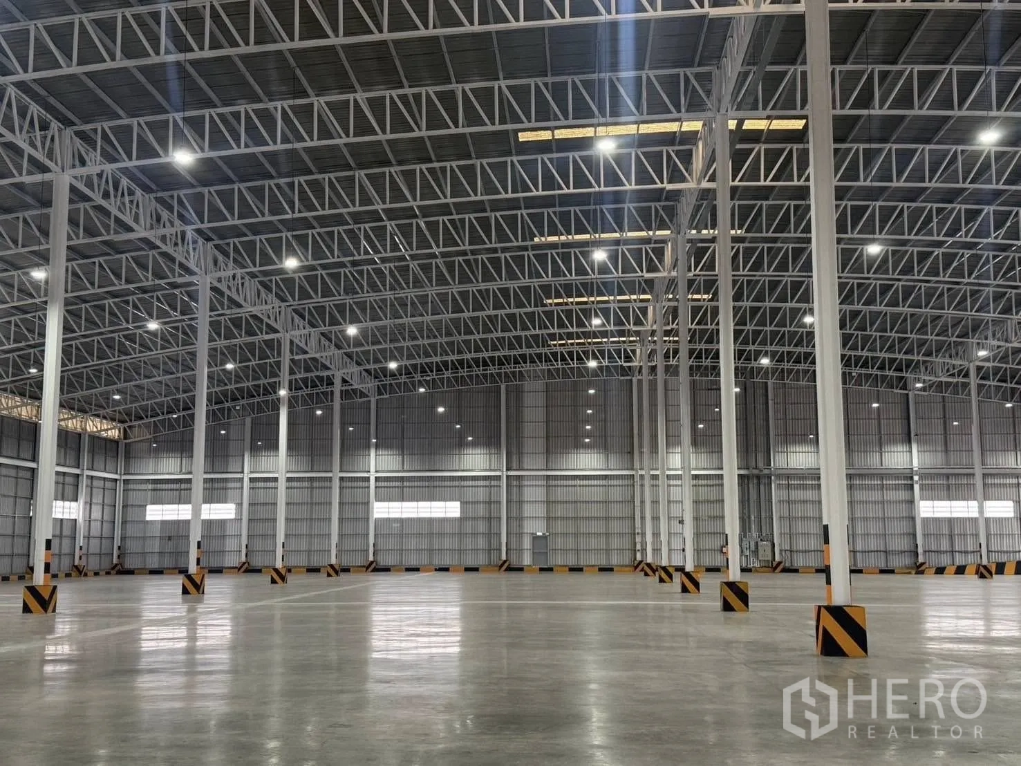 工厂 for rent in Si Racha, Chon Buri - 钢柱与桁架细部特写，抛光地坪清晰可见。