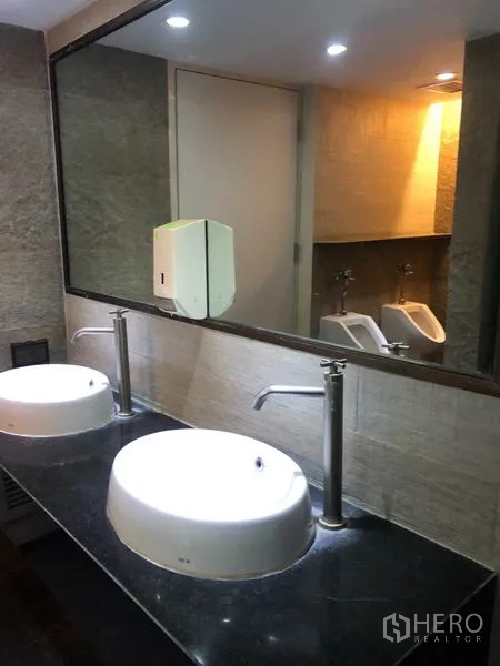 Office Space for rent in Watthana, Bangkok - Double vanity with round basins, tall faucets, and a large mirror in the washroom.
