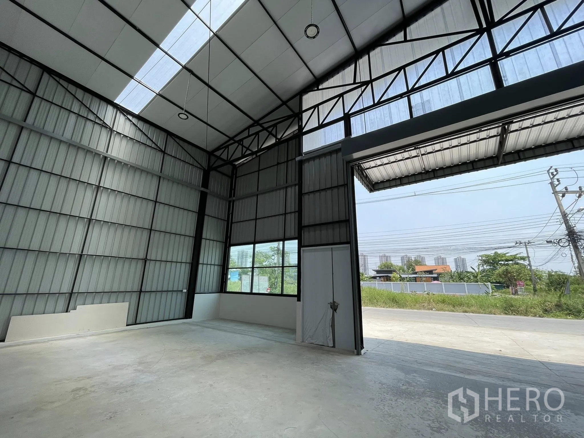 仓库 for rent in Pak Kret, Nonthaburi - 前部室内区域，超大入口通向道路与转角窗。
