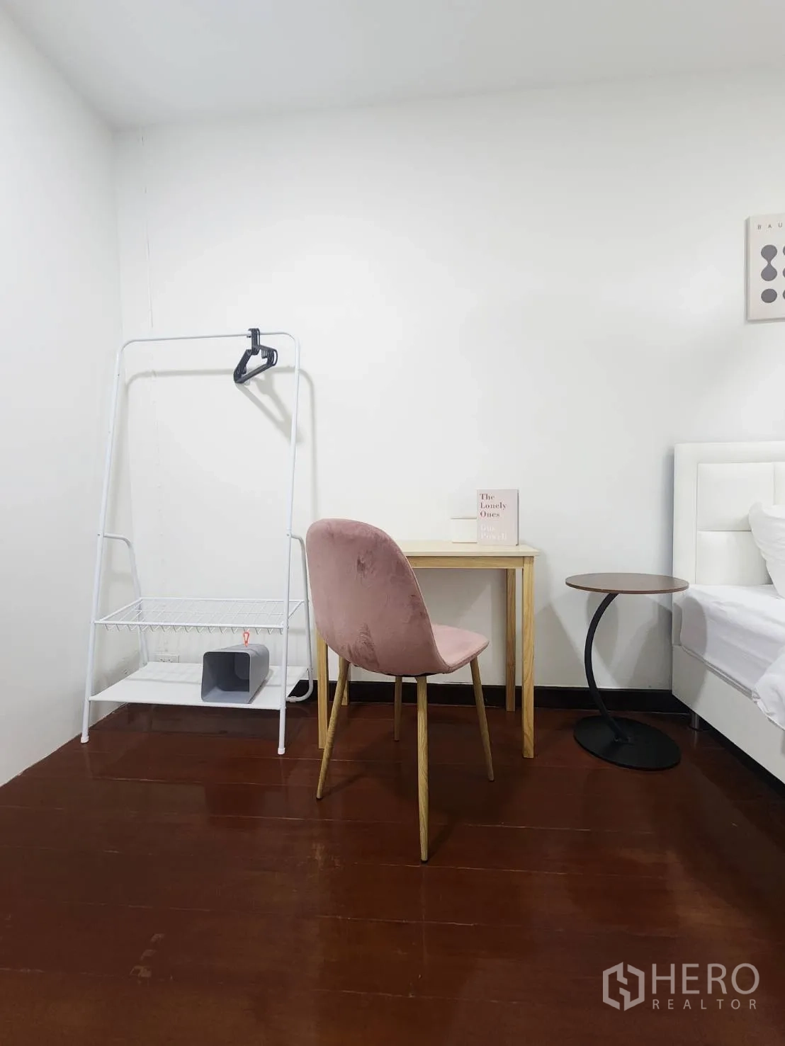 Detached House for rent in Huai Khwang, Bangkok - Corner with desk and pink chair beside an open clothes rack on wooden flooring.