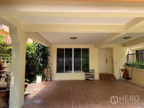 Detached House for rent in Watthana, Bangkok - Covered carport with tiled floor, pillars, sliding glass door and garden edging.