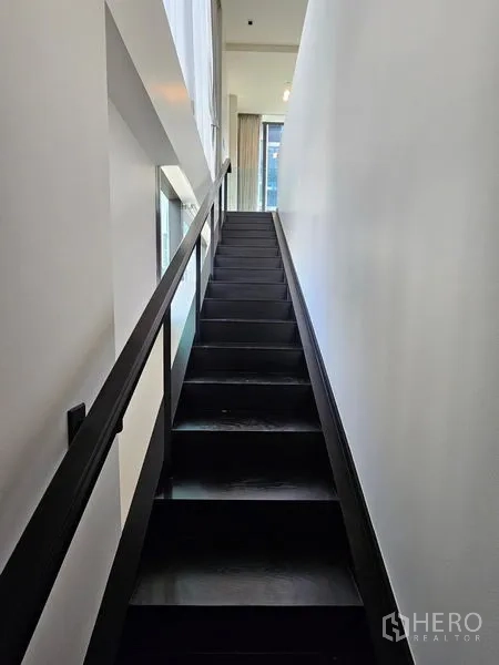 Condominium for rent - Stairway corridor with side window panels and glass balustrade.