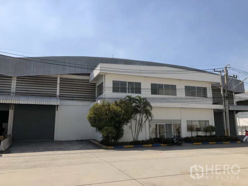 Warehouse for rent in Phra Nakhon Si Ayutthaya - Angled exterior of the warehouse complex with white office block, loading bay and wide driveway.