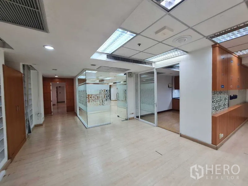 Office Space for rent in Ratchathewi, Bangkok - Glass-partitioned rooms and reception area with built-in cabinets and bright ceiling lights.