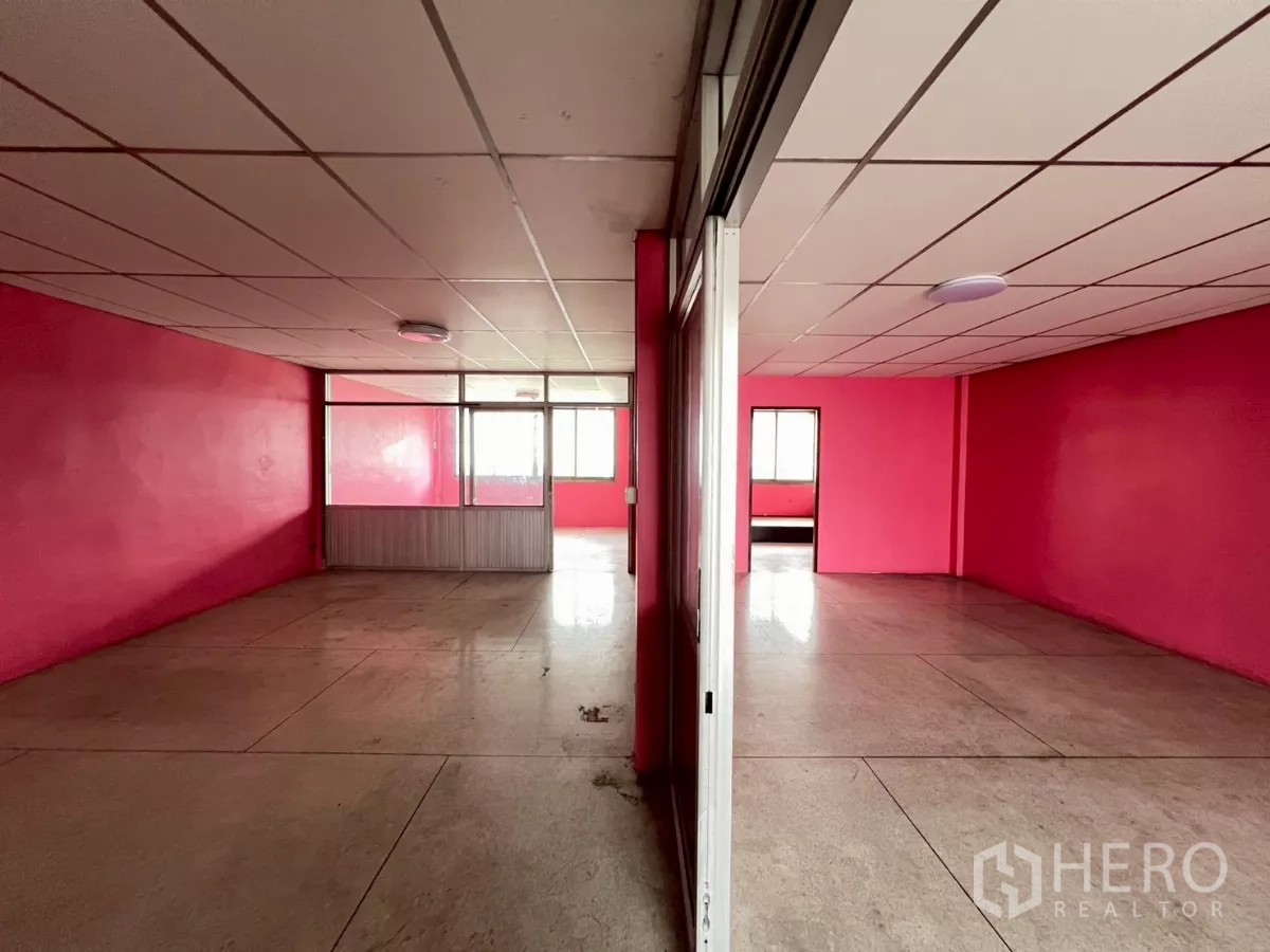 Shophouse for rent in Watthana, Bangkok - Two adjacent rooms divided by a sliding partition with bright windows at the far end.