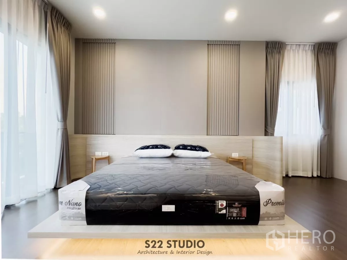 Detached House for rent in Bang Phli, Samut Prakan - Close-up of the master bed with paneled headboard and sheer curtains on two sides.