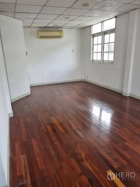 Detached House for rent or sale in Sathon, Bangkok - Long upstairs room with wooden floorboards and wall-mounted air conditioner.