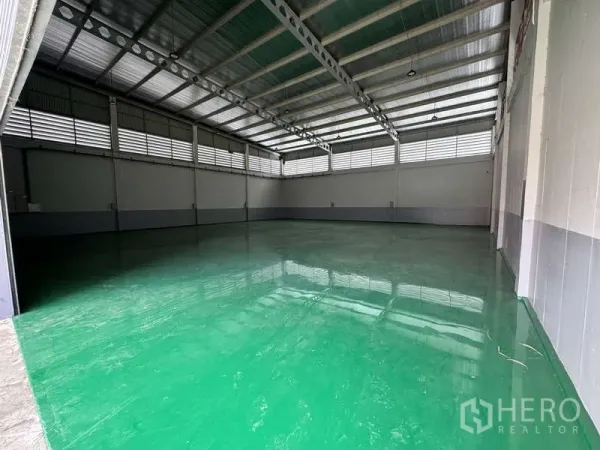Factory for rent or sale in Lam Luk Ka, Pathum Thani - Spacious high-bay warehouse interior with steel roof and glossy green epoxy floor.