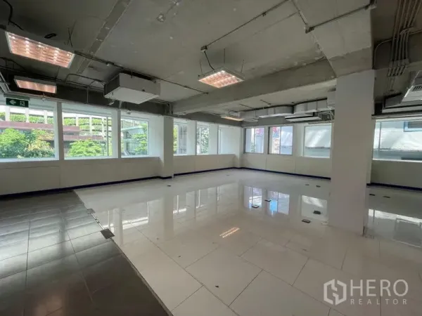 Office Space for rent in Ratchathewi, Bangkok - Open-plan office space for rent in Ratchathewi, Bangkok with large windows, white tiles and exposed ceiling.