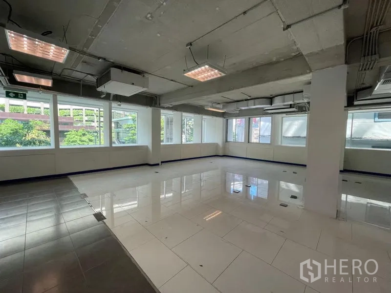 Office Space for rent in Ratchathewi, Bangkok - Open-plan office space for rent in Ratchathewi, Bangkok with large windows, white tiles and exposed ceiling.