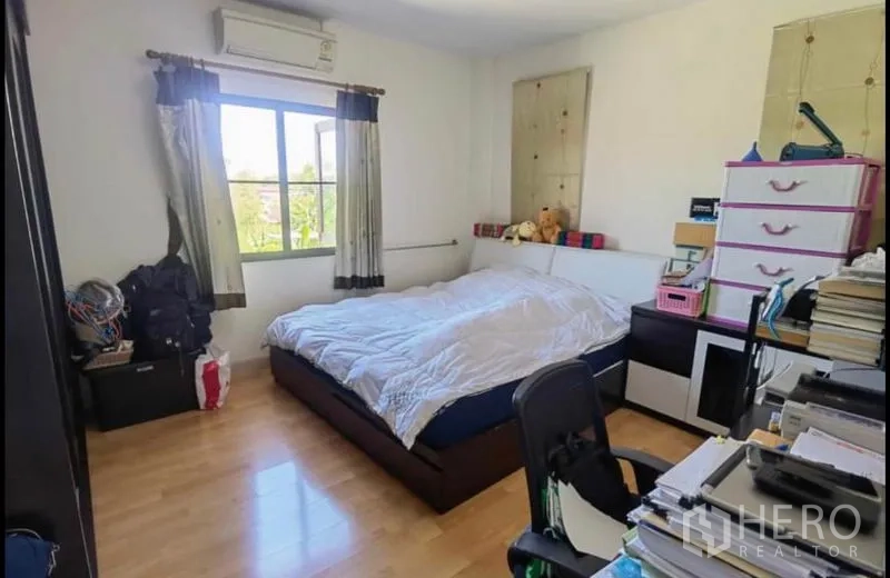 Detached House for sale in Bang Yai, Nonthaburi - Bright bedroom with wood floors, desk space and window views.