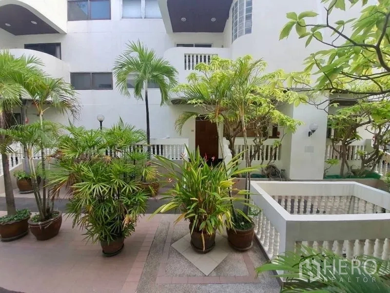 Townhouse for rent in Sathon, Bangkok - Townhouse courtyard with potted tropical plants and white balustrades.