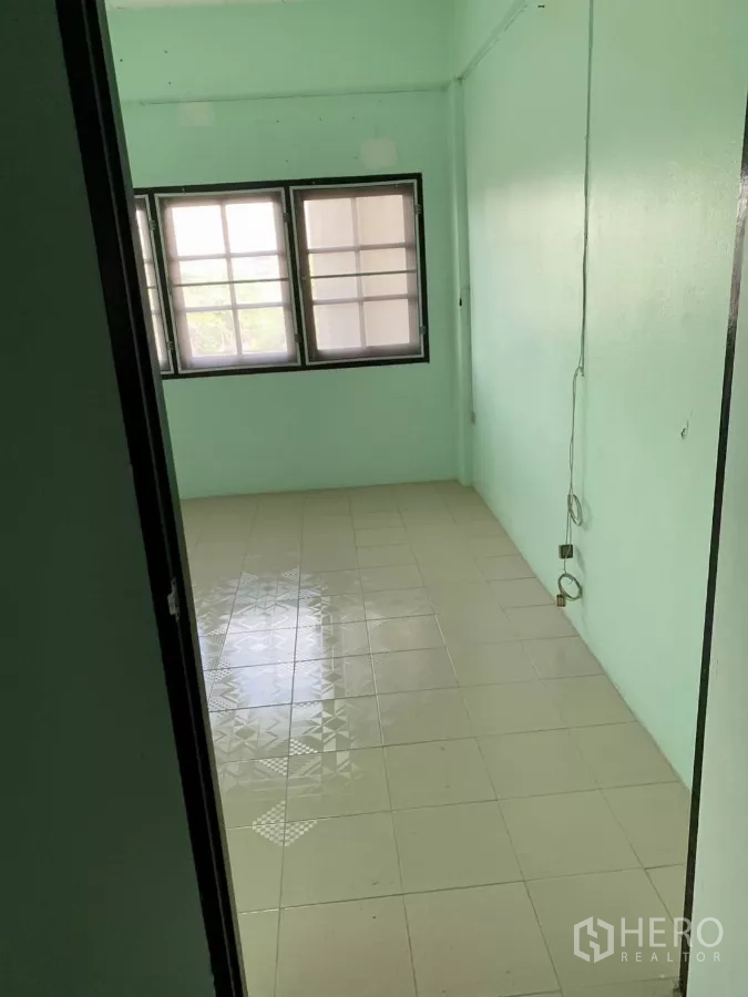 Shophouse for rent in Suan Luang, Bangkok - Narrow tiled room with windows and power outlets.