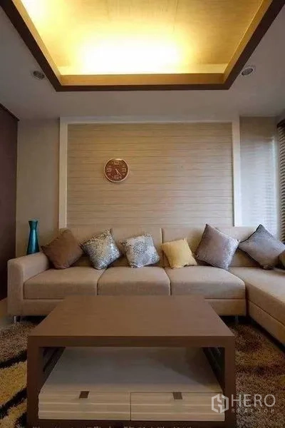 Townhouse for rent in Phra Khanong, Bangkok - Close-up of living room sofa set beneath recessed ceiling lighting.