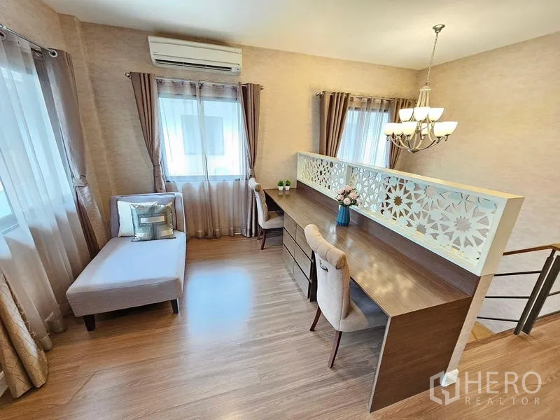 Detached House for rent in Prawet, Bangkok - Upstairs family area with long built-in work desk, chandelier, and stairway screen.