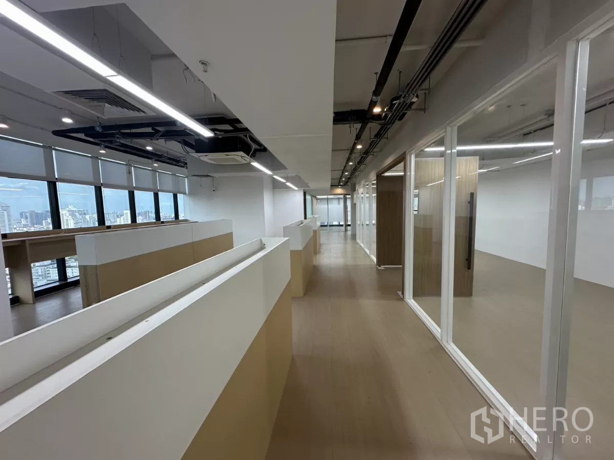 Office Space for rent in Watthana, Bangkok - Open workspace with built-in bench, window blinds, and cubicle dividers.