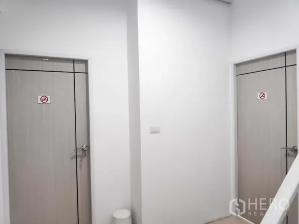 带办公室的家 出租在Khlong Toei, Bangkok - 走廊内两扇浅木色门与白墙，可作独立卫生间或储物间。