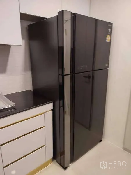 Detached House for rent in Bang Phli, Samut Prakan - Sleek black double-door refrigerator next to white kitchen cabinetry.