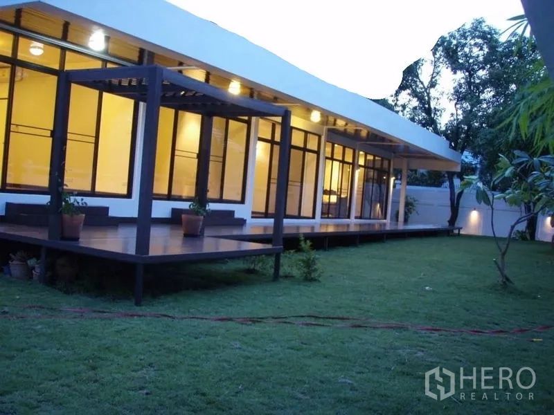Detached House for rent in Huai Khwang, Bangkok - Long deck with pergola overlooking wide grassy yard around the house