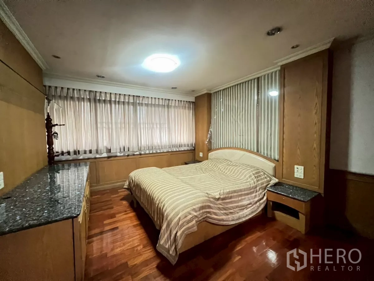 Shophouse for rent in Bang Rak, Bangkok - Bedroom with built-in wardrobes, large windows and wood floors.