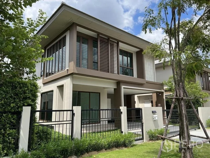 Detached House for sale in Bang Kapi, Bangkok - Exterior corner view of the house with fence, shrubs and sun-shade louver panels.