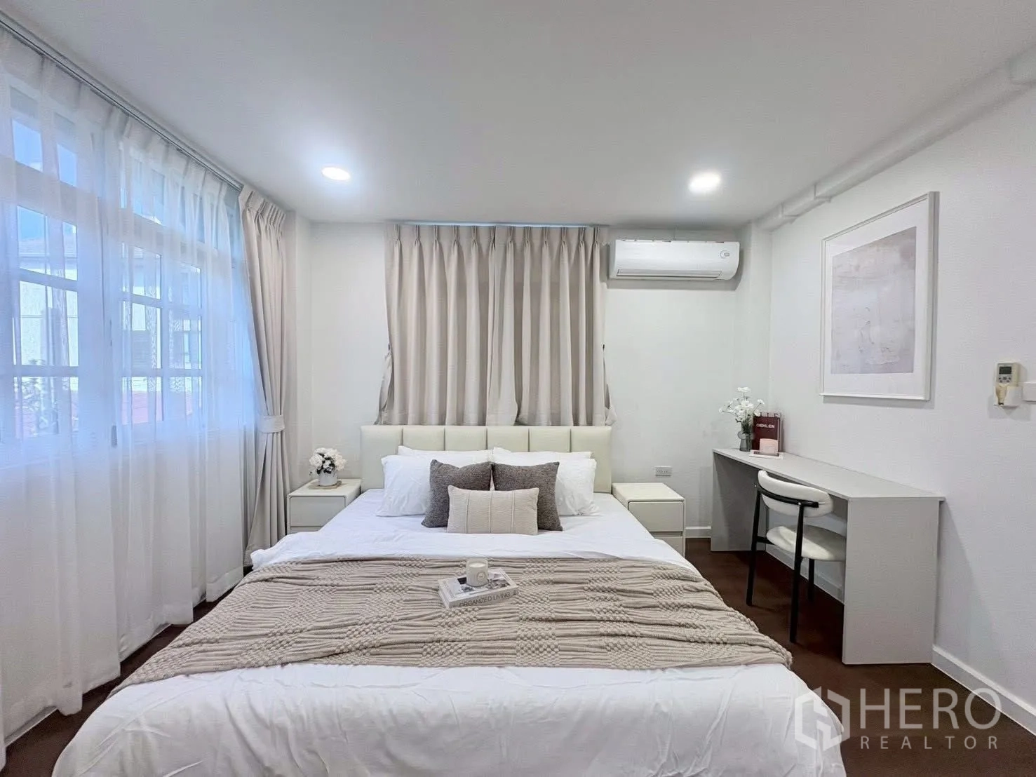Townhouse for rent in Huai Khwang, Bangkok - Bedroom with bed, side tables, and a work desk under soft lighting.