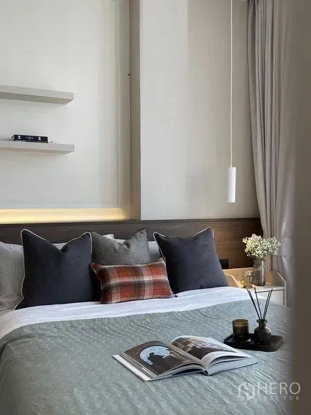 Condominium for rent in Pathum Wan, Bangkok - Close-up of a neatly styled bed with layered cushions, pendant light and bedside table.