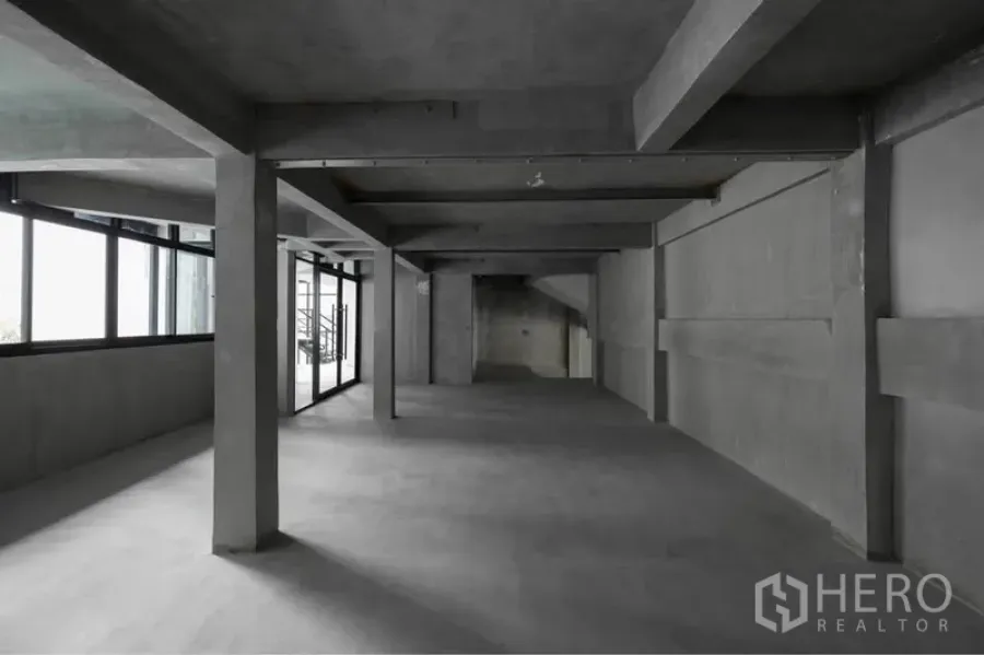 Retail Space for rent in Watthana, Bangkok - Spacious open-plan retail floor with exposed concrete beams, pillars, and large side windows providing natural light.