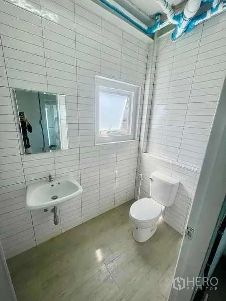 Home Office for rent or sale in Bang Kapi, Bangkok - Renovated bathroom with white subway tiles, window ventilation, and modern fixtures.