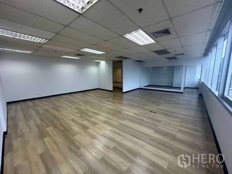 Office Space for rent in Phra Khanong, Bangkok - Large open office zone with wood flooring and a continuous row of side windows for natural light.
