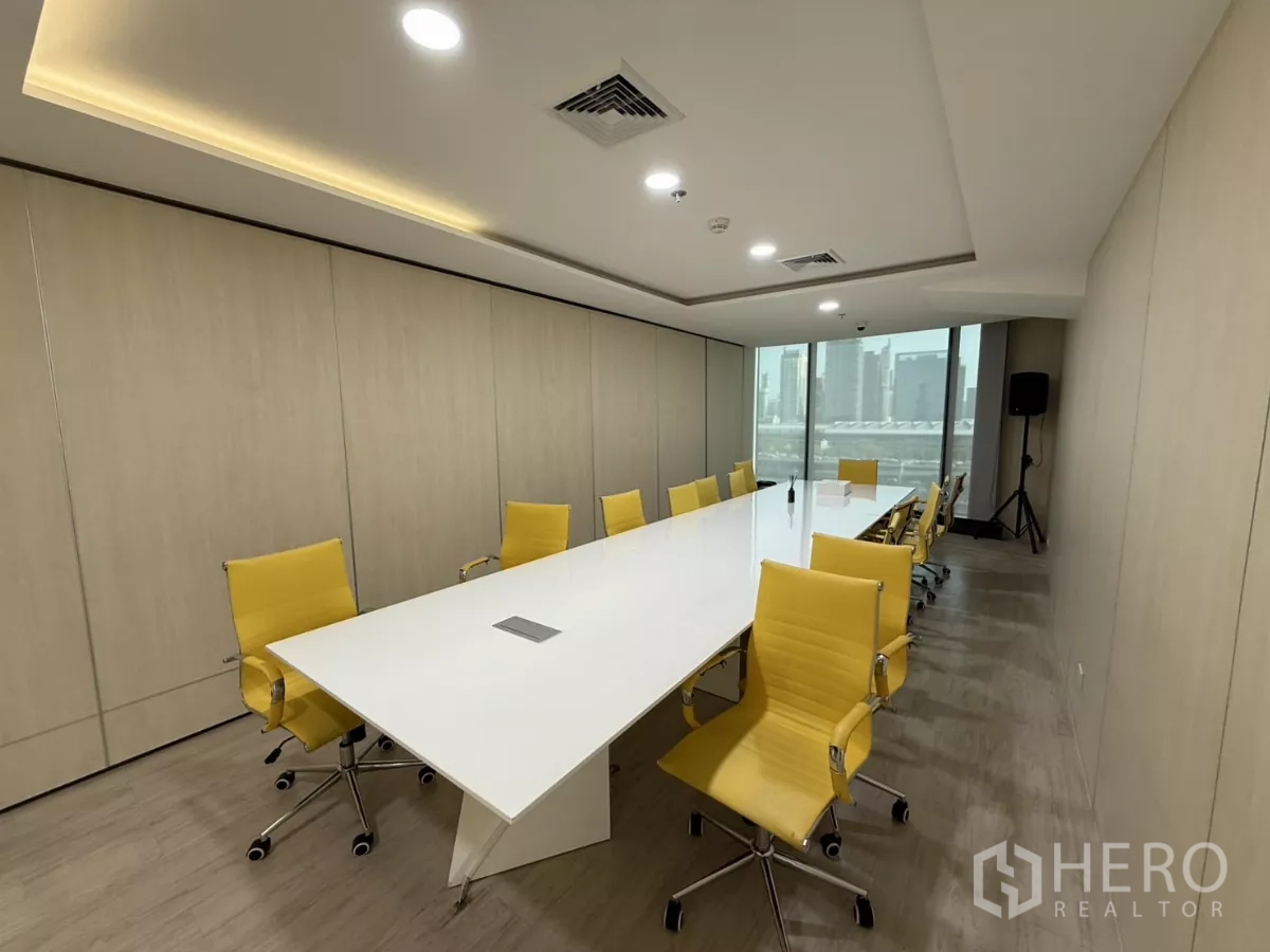 Office Space for rent in Din Daeng, Bangkok - Contemporary boardroom with a long white conference table, yellow chairs, recessed lighting and city views through large windows.