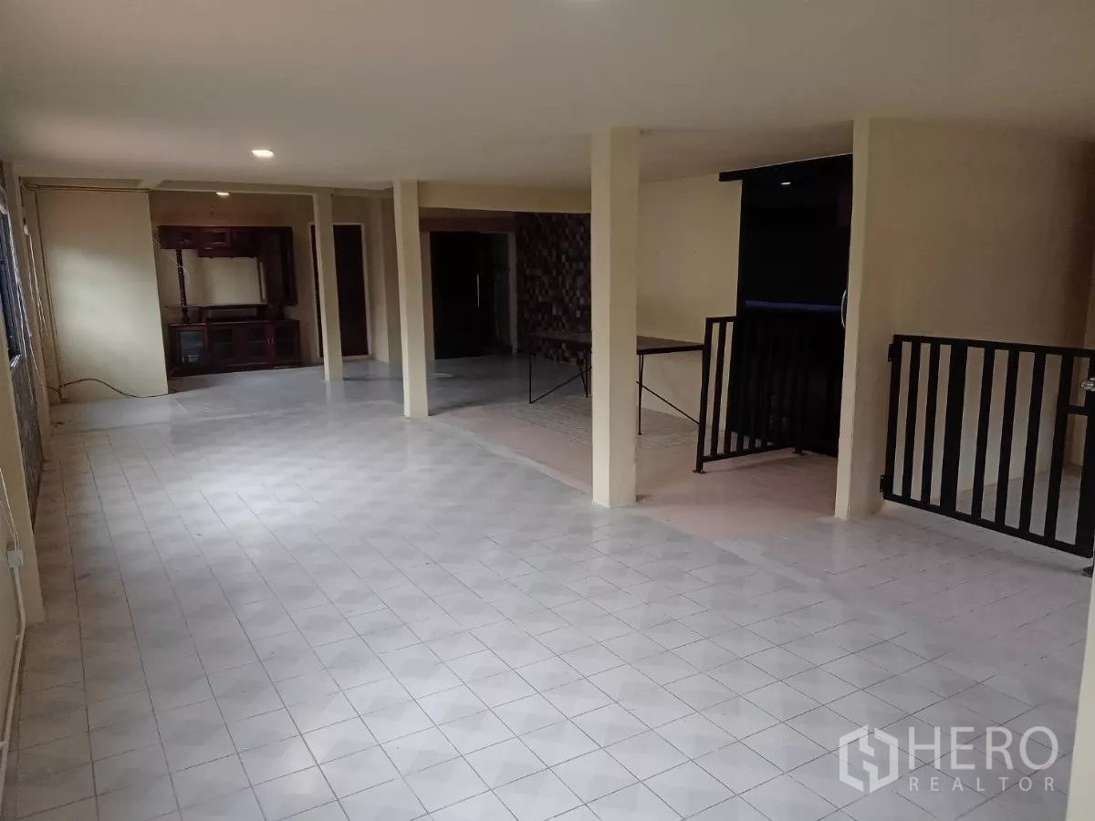 Detached House for rent in Phaya Thai, Bangkok - Long open living hall with tiled floors and multiple columns.