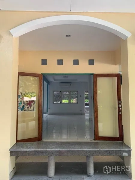 Detached House for rent in Khlong Toei, Bangkok - Arched entrance with double wooden doors opening to the bright living area.
