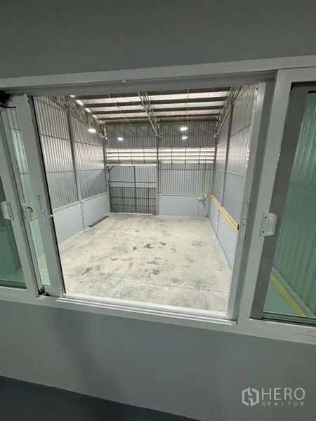 Warehouse for rent in Mueang Pathum Thani, Pathum Thani - View from the office window overlooking the warehouse floor and entry door.