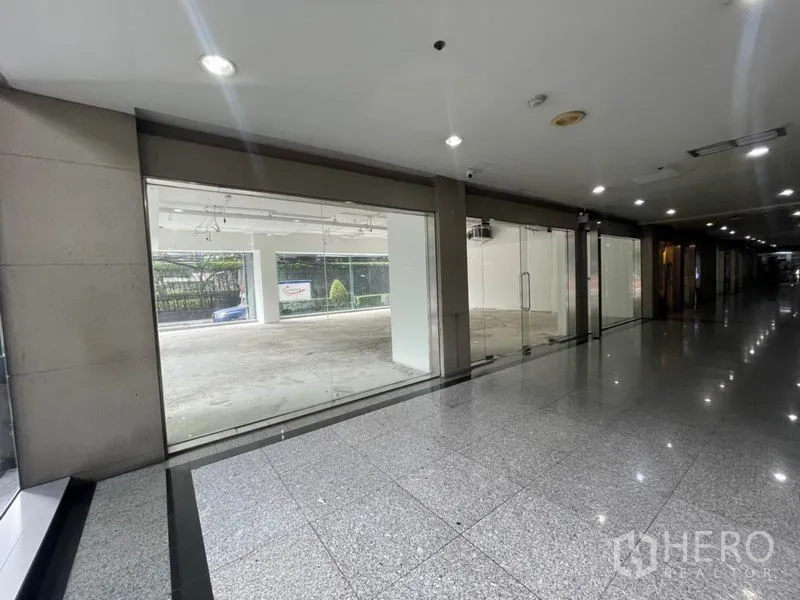 Retail Space for rent in Watthana, Bangkok - Ground-floor retail unit with full-height glass shopfront facing a polished lobby corridor.