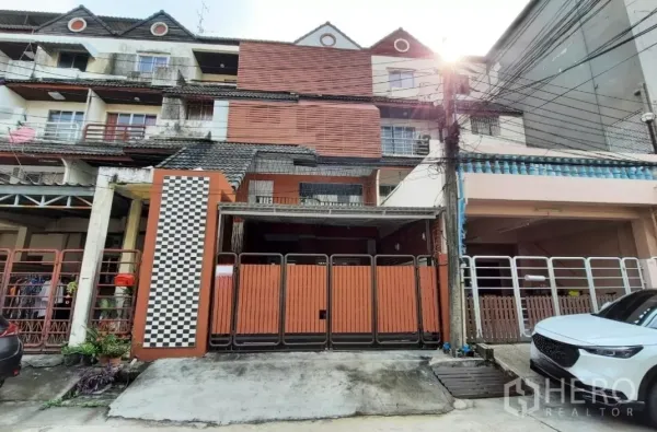 ทาวน์เฮาส์ ขายในSuan Luang, Bangkok - มุมมองด้านหน้า ประตูบานพับเหล็กและทางรถเข้า