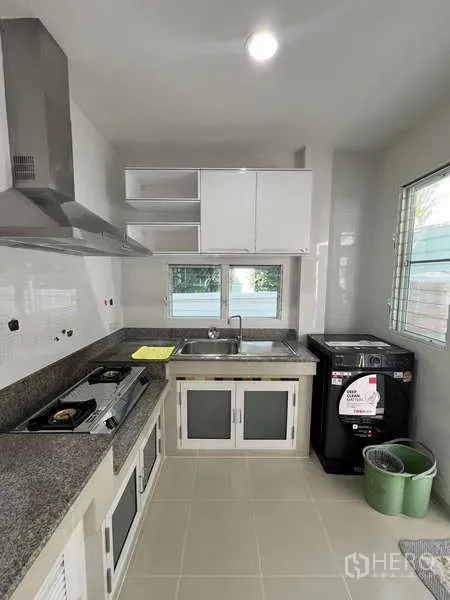 Detached House for rent in Bang Kapi, Bangkok - Thai kitchen with granite counters, gas hob, range hood, sink and window light.