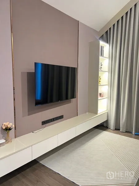 Detached House for sale in Bang Kapi, Bangkok - Bedroom media wall with mounted TV, floating cabinet and lighted shelving.