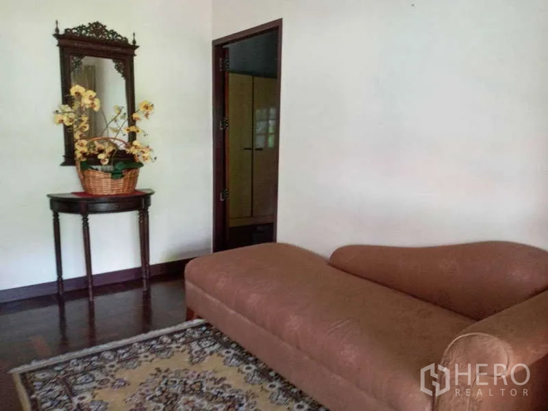 บ้าน ให้เช่าในKhlong Toei, Bangkok - ห้องนั่งเล่นเล็กพร้อมเก้าอี้ยาว กระจก และพรม