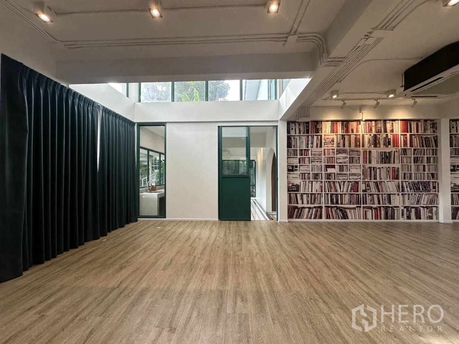 带办公室的家 出租或出售在Phra Khanong, Bangkok - 带天窗的宽敞多功能室，木地板与书架主题墙