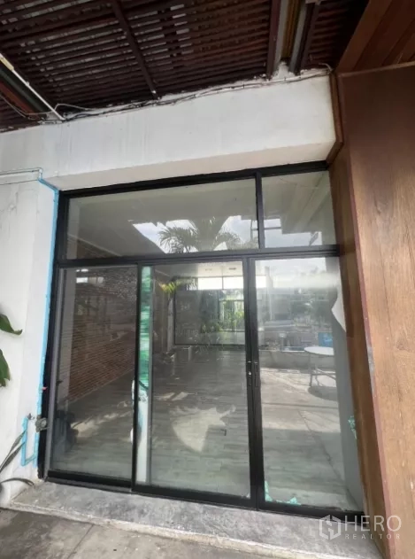Retail Space for rent - Square glass storefront with black aluminum frame opening to a bright courtyard.