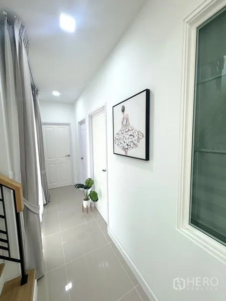 Detached House for rent - Clean hallway with white doors, artwork and recessed lighting.