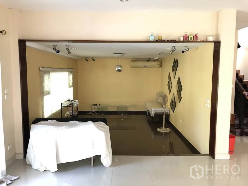 Detached House for rent or sale in Bang Kapi, Bangkok - Sunken lounge with track lighting, accent wall and window blinds.