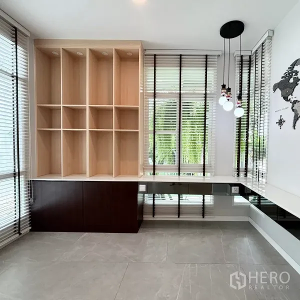 Detached House for rent or sale in Prawet, Bangkok - Sunlit study corner with built-in shelves, wraparound windows with blinds and pendant lights.
