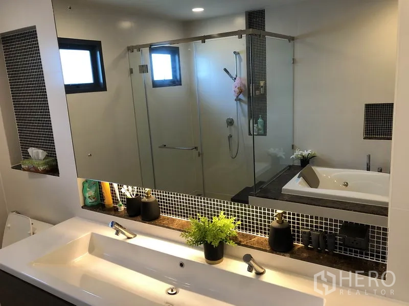 Detached House for rent in Bang Kapi, Bangkok - Modern bathroom with double vanity, large mirror, glass shower and bathtub.
