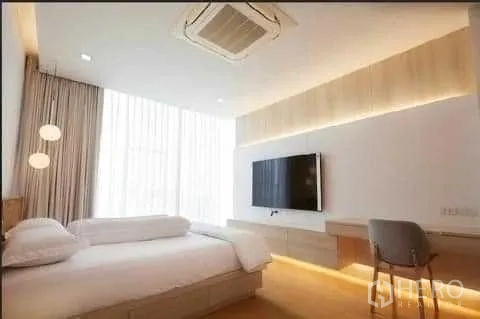 联排别墅 出租在Huai Khwang, Bangkok - 卧室配壁挂电视、书桌与柔和灯光，纱帘高至天花板。