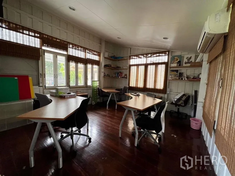 Townhouse for rent - Corner office room with windows on two sides and multiple workstations.