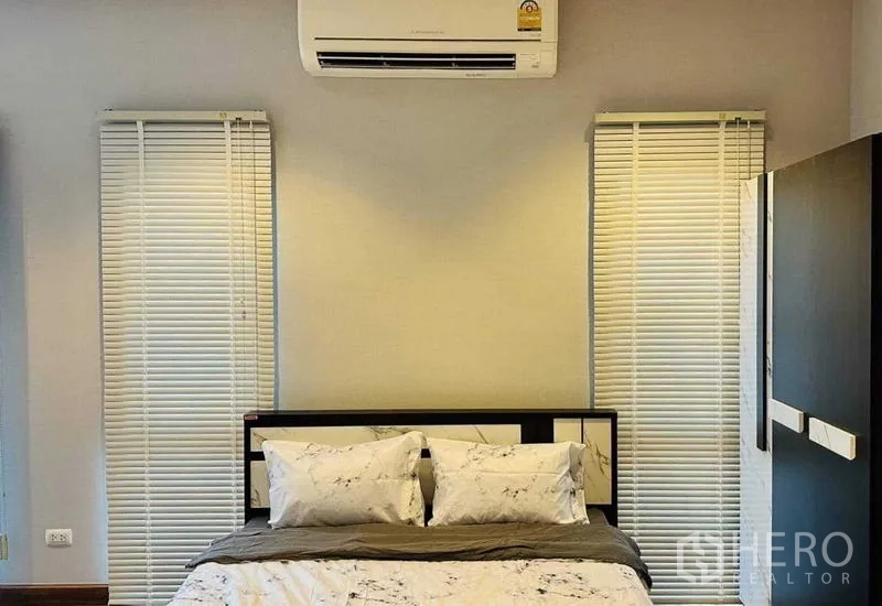 Detached House for rent in Lam Luk Ka, Pathum Thani - Secondary bedroom with air conditioner and slim windows with blinds.